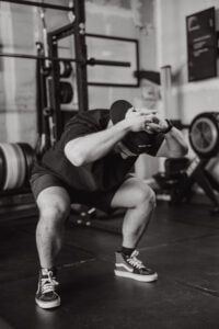 Physical therapist demonstrating squat for to minimize knee pain