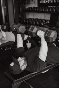 Athlete performing dumbbell press after improving nerve pain