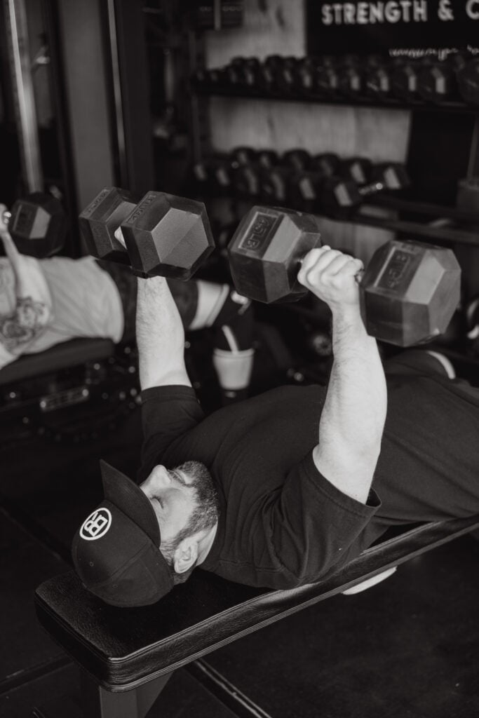 Athlete performing dumbbell press after improving nerve pain