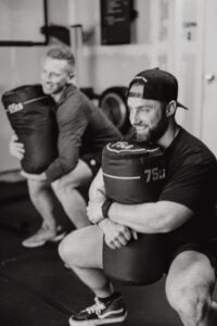 Athlete lifting heavy sandbag to release tight hip flexors
