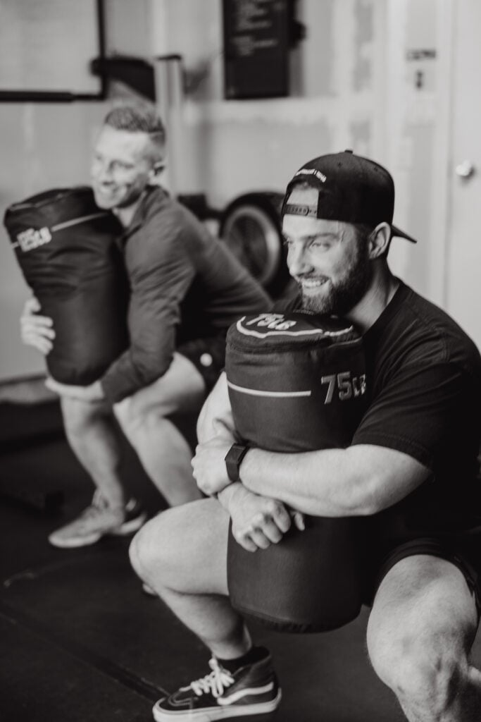 Athlete lifting heavy sandbag to release tight hip flexors
