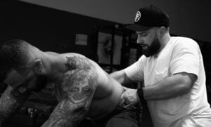 Athlete performing mobility exercise with physical therapist to relieve pain and improve strength